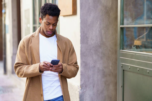 istock Young black man using his smartphone outdoors. 1397549231
