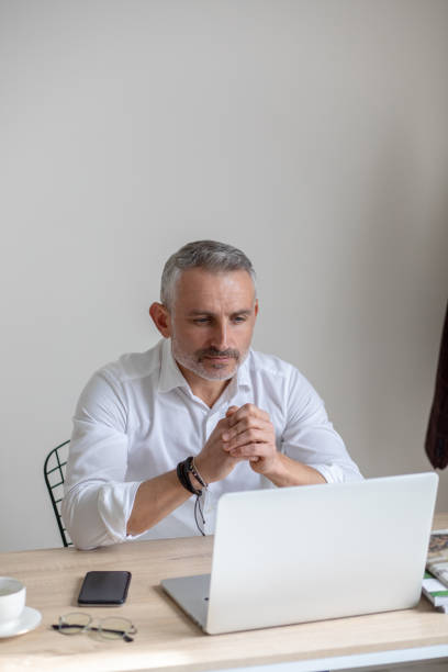 istock Attentive business man looking at laptop sitting at table 1397549832