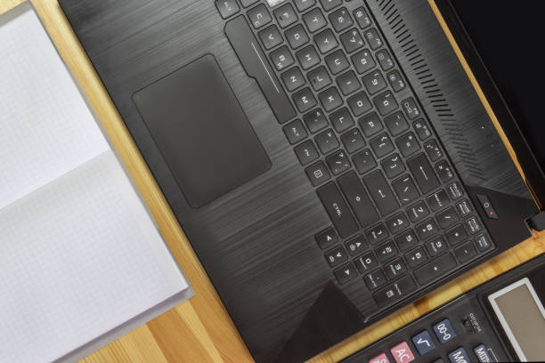 istock Keyboard, calculator and notepad on a wooden background. 1397550611