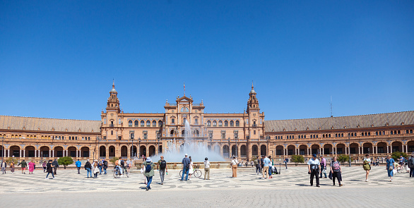 Seville, Spain - 7th April 2022 Locals and tourists relaxing and enjoying a sunny April day in Seville's Plaza de España, which was designed by Anibal Gonzalez and completed in 1929  as the Pabellon de Andalucia for Expo 29.
