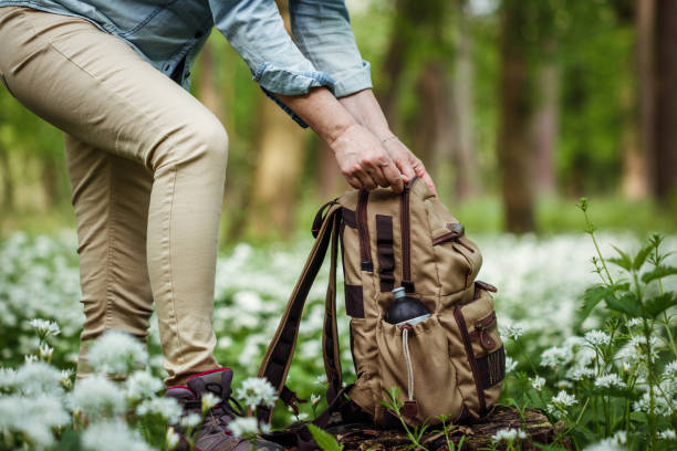 istock Woman opening backpack during hiking in spring forest. 1397551031