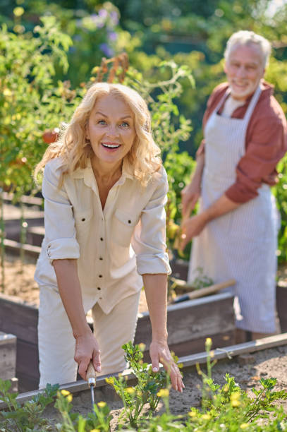 istock Woman smiling at camera working near vegetable garden 1397551252