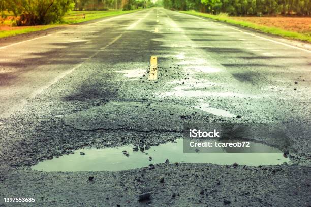 Puddles On The Road When It Rains Stock Photo - Download Image Now - Sinkhole, Road, Reflection