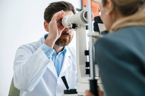 Optometrist checks the patient's intraocular pressure in optician's shop or ophthalmology clinic stock photo
