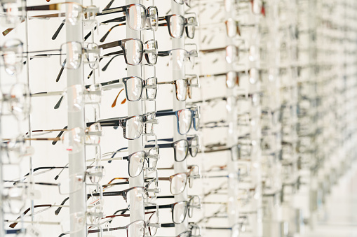 Stand with glasses in the store of optics. Showcase with spectacles in modern eyeglasses shop