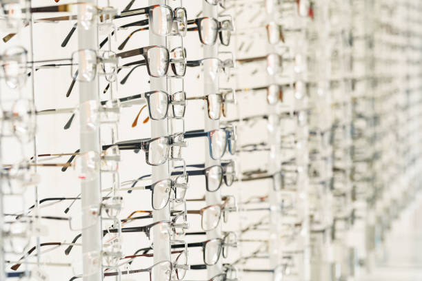 Stand with glasses in the store of optics. Showcase with spectacles in modern eyeglasses shop stock photo