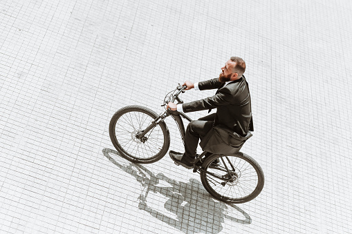 Fun Times For Bearded Businessman Enjoying Riding Bicycle To Work