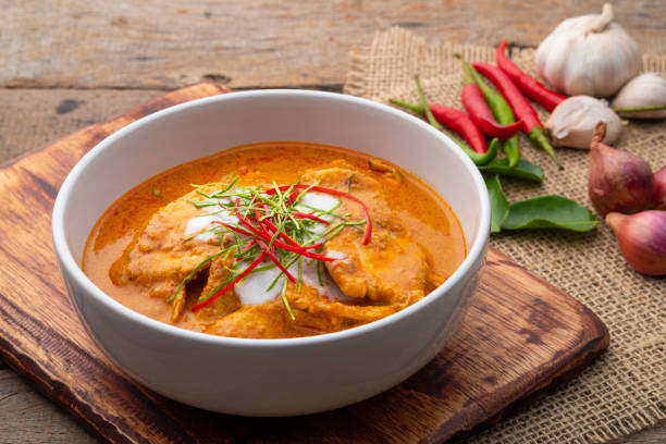 panaeng curry com frango. peito de frango fatiado carne em pasta de curry vermelho e leite de coco, cobertura com creme de coco e folhas de limão kaffir desfiados - caril - fotografias e filmes do acervo