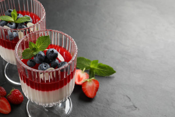 istock Delicious panna cotta with fruit coulis and fresh berries on dark grey table. Space for text 1397565050