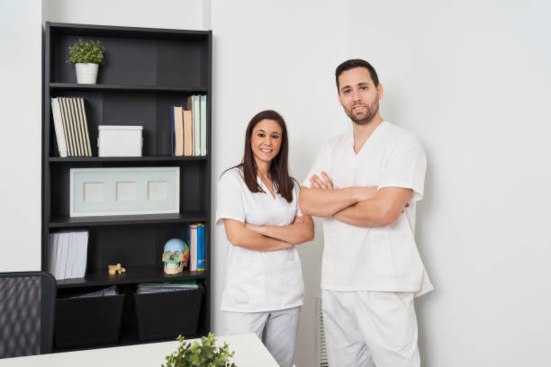 portrait of two physiotherapists in their clinic looking at the camera stock photo
