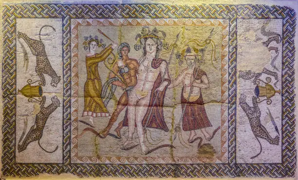 Mosaic of the Triclinium of the House of Bacchus. Mosaic representing the God Bacchus with part of his entourage, including a satyr on which the god is leaning. A scene flanked with figures of leopards facing a krater."nRoman city of Complutum (Alcala de Henares). 5th century AD."n"n"n