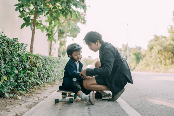 istock Asian father and son skateboarder practicing in the public park. 1397572095