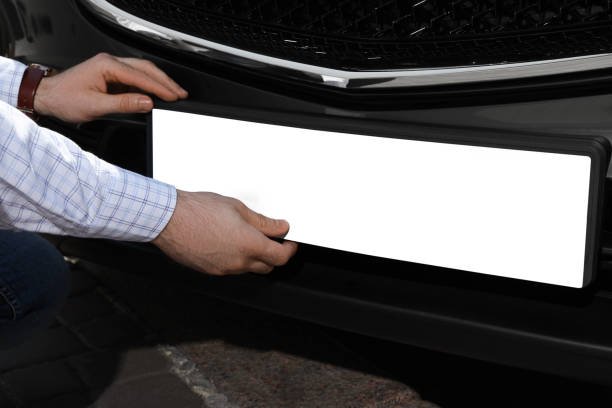 istock Man installing vehicle registration plate outdoors, closeup. Mockup for design 1397573192