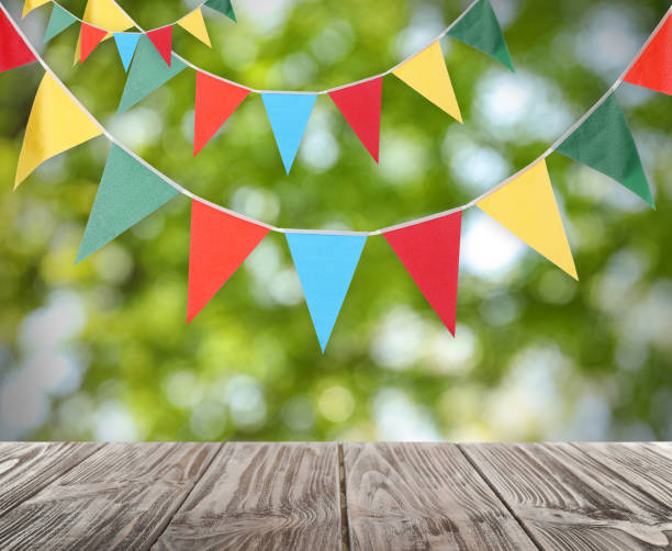 istock Empty wooden table and decorative bunting flags outdoors 1397574402