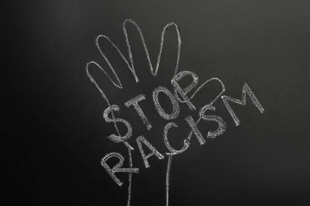 istock Chalked inscription Stop Racism and raised hand on blackboard 1397574805