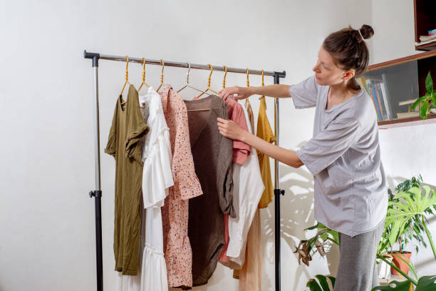 istock Woman hangs clothes on a rail at home. Sorting wardrobe and second hand. The concept of sustainable living 1397577861