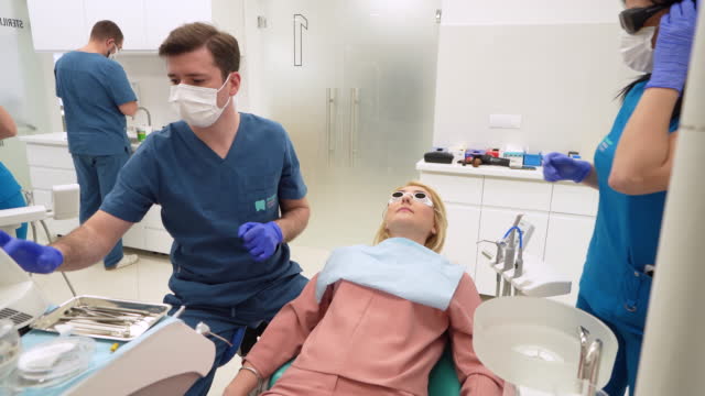 Male dentist adjusting infrared descaling drill, before he start with a procedure