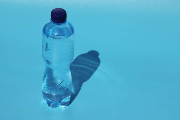 istock Bottle of cold water on blue background 1397583647