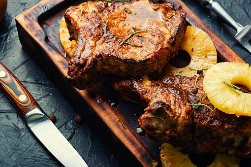 Delicious beef entrecote grilled with pineapple on cutting board