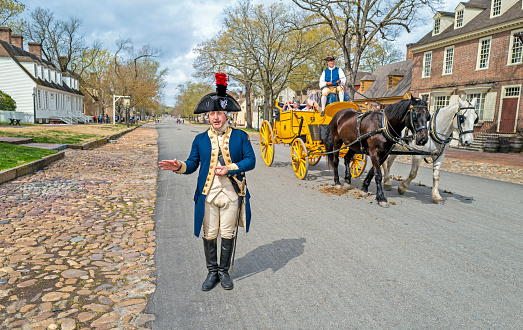 Williamsburg, Virginia, USA: 31st March 2021; Major General Marquis De Lafayette in downtown colonial Williamsburg talking as a carriage passes by.