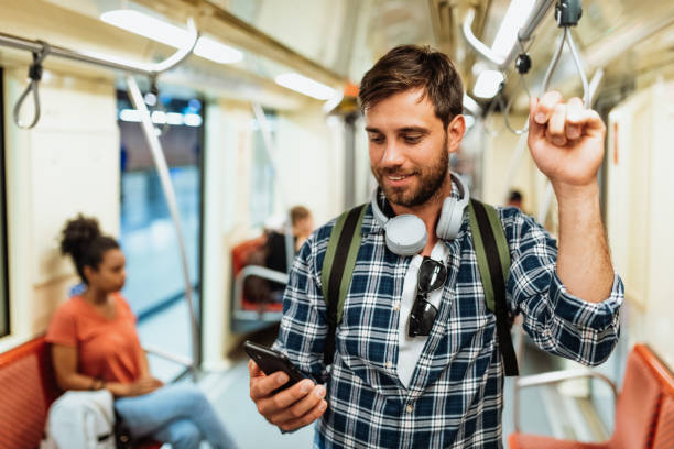istock Diverse students and employees in city commuting by metro line. Man using mobile app or e-banking on smart phone while riding 1397593035