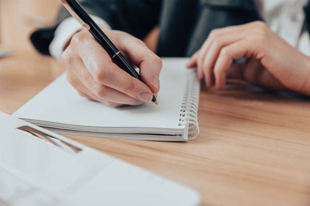 istock Man hand holding pen reading paper work 1397594226