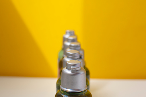 Travel kit. Set of plastic bottles for cosmetic products. Yellow background with shadows.