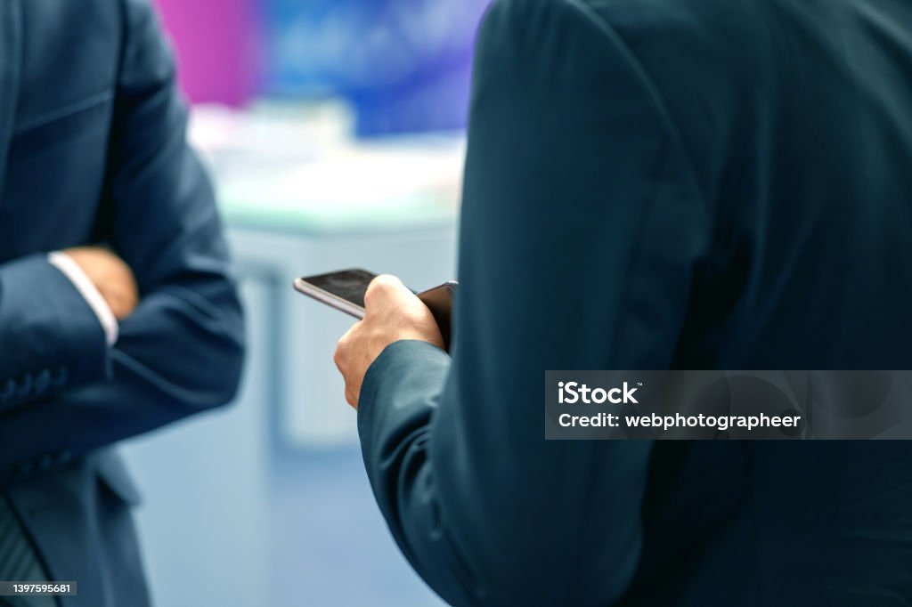 Businessman taking notes while socializing, Nikon Z7 Close-up of businessman taking notes using smart phone while socializing after a business meeting, Nikon Z7 Adult Stock Photo