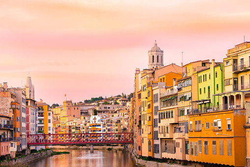 Girona Spain with canal and historic colorful buildings seen at sunset.