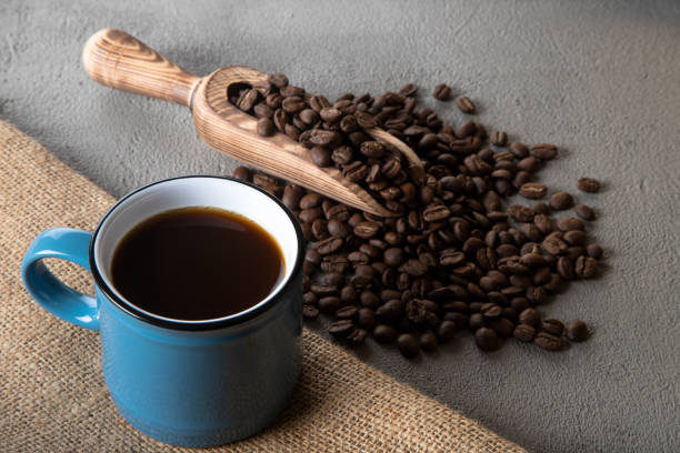 istock Blue cup of coffee with coffee beans on concrete background 1397599839