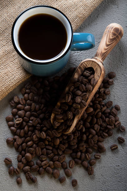 istock Blue cup of coffee with coffee beans on concrete background 1397601854