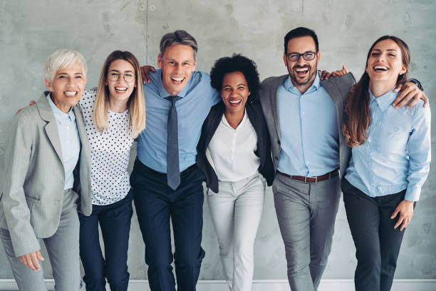 Together we make a great team Group of smiling business persons standing together locking-arms stock pictures, royalty-free photos & images