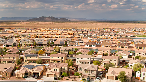 Aerial shot of Maricopa, Arizona, flying over a growing housing development being built around an artificial lake.
