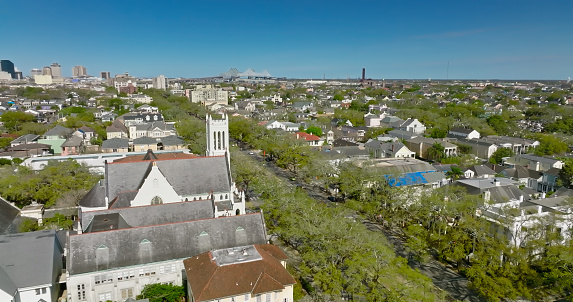 Aerial shot of New Orleans, Louisiana on a clear sunny day, flying over residential streets in Mid-City, looking towards the skyline of the Central Business District.