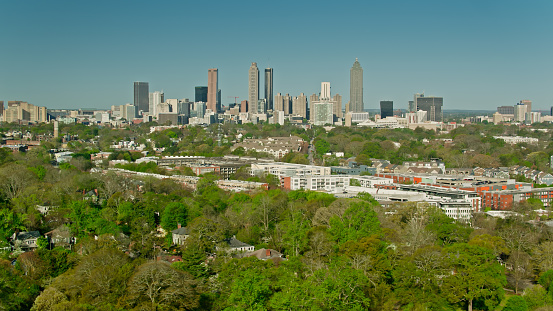 Aerial shot of Atlanta, Georgia on a sunny spring day, looking towards the downtown skyline over residential streets from Little Five Points. \n\nAuthorization was obtained from the FAA for this operation in restricted airspace.