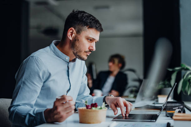 istock Businessman Having A Lunch Break At Desk In The Office 1397610406