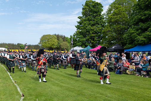 15 May 2022. Gordon Castle, Fochabers, Moray, Scotland. This is the massed Pipe Bands performing at Gordon Castle Highland Games & Country Fair on a sunny day.