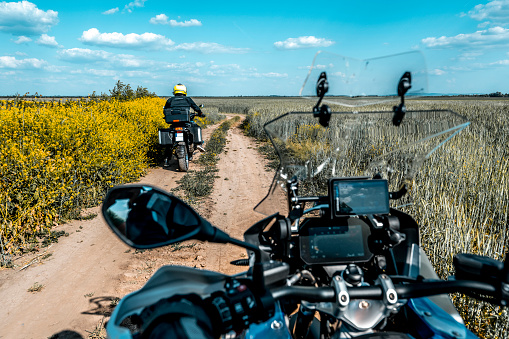 Personal perspective of an enduro moto bike rider who is enjoying the riding adventure in a beautiful nature with his friend during one sunny spring day.