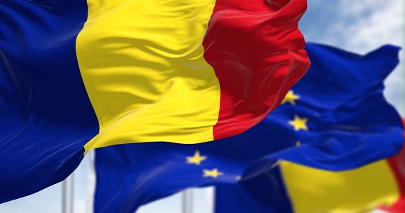 Detail of the national flag of Romania waving in the wind with blurred european union flag