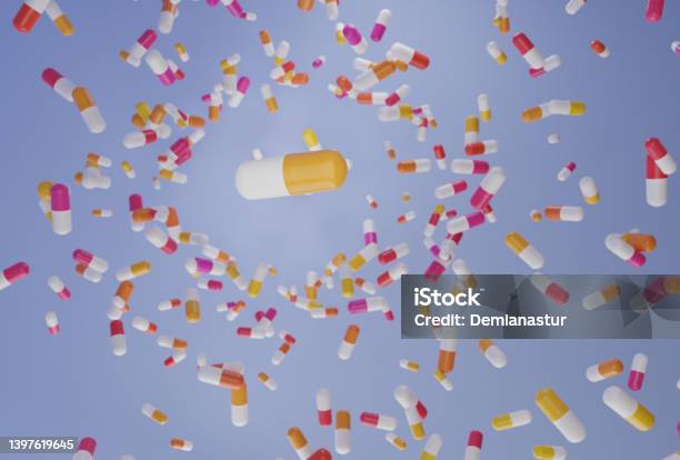 A Group Of Antibiotic Pill Falling On A Blue Background Healthcare And Medical 3d Concept Stock Photo - Download Image Now