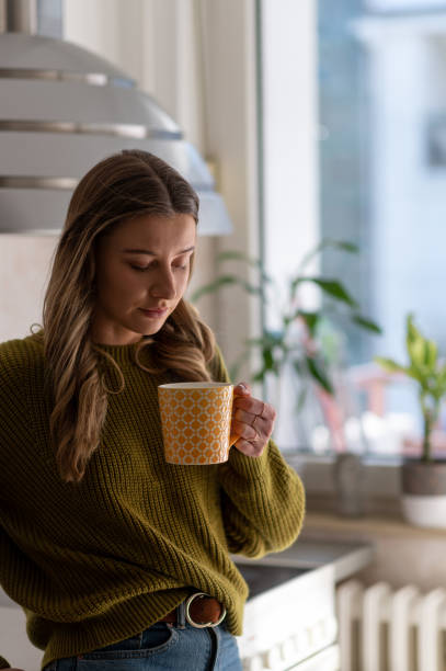 istock Woman standing in the kitchen and drinking cup of tea 1397623017