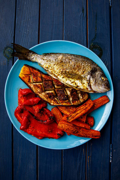 Fried dorado fish with vegetables.