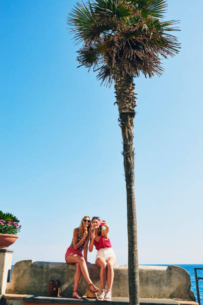 istock Two friends taking selfies eating ice cream on beach using smart phone to connect on adventure travel 1397626641