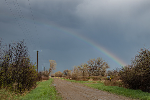 Thunderstorm with high winds rolls through Montana ranch land prairie leaving rainbow in central Montana in northwestern United States of America (USA).