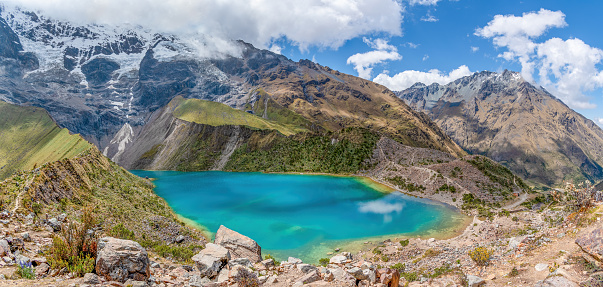 Humantay Lake,  Cusco, Peru - May 9, 2022;  The Humantay Lake  is located about 75 miles to the northwest of Cusco and just south of Machu Picchu. The lake can be found between Humantay Mountain and Salkantay Mountain.  Humantay Lake is most well known for its bright blue water. This colour comes from the mineral-filled runoff from the melting glaciers around the Humantay and Salkantay Mountains.