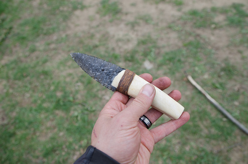 Close up on handmade knife with obsidian rock and animal bone