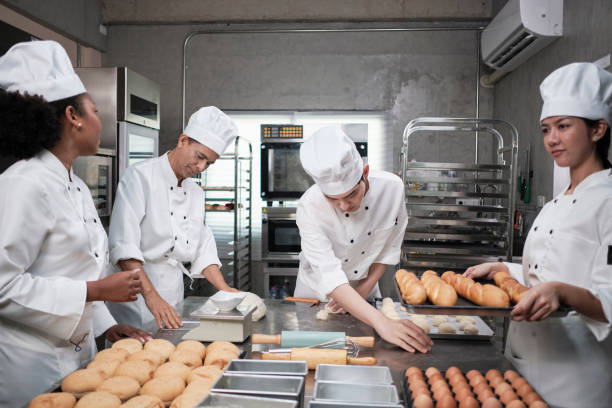 istock Chefs team in uniforms prepare to bake bread and pastry in stainless kitchen. 1397634856