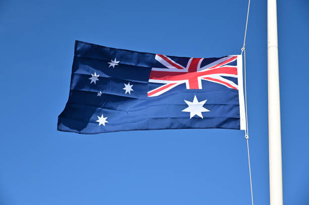 istock Australia national flag waving against blue sky 1397635673
