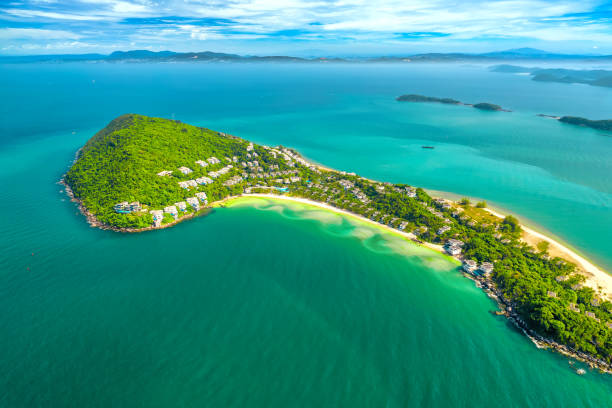 Small tropical island in the ocean with many resorts, aerial view stock photo