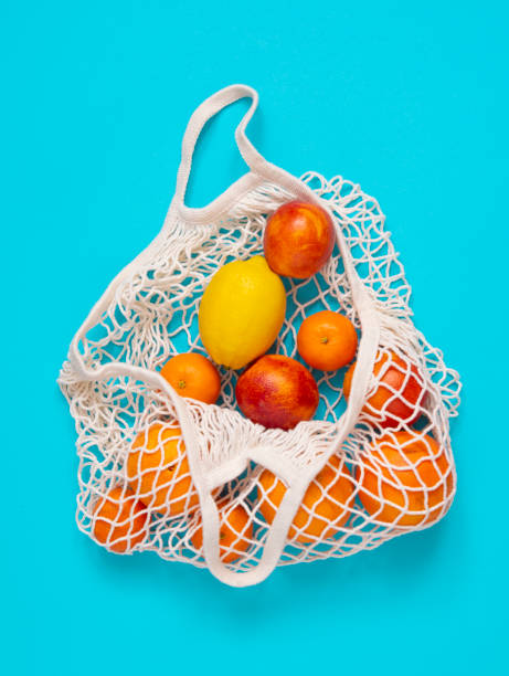istock Citrus fruits in a string bag on a blue background. 1397636875